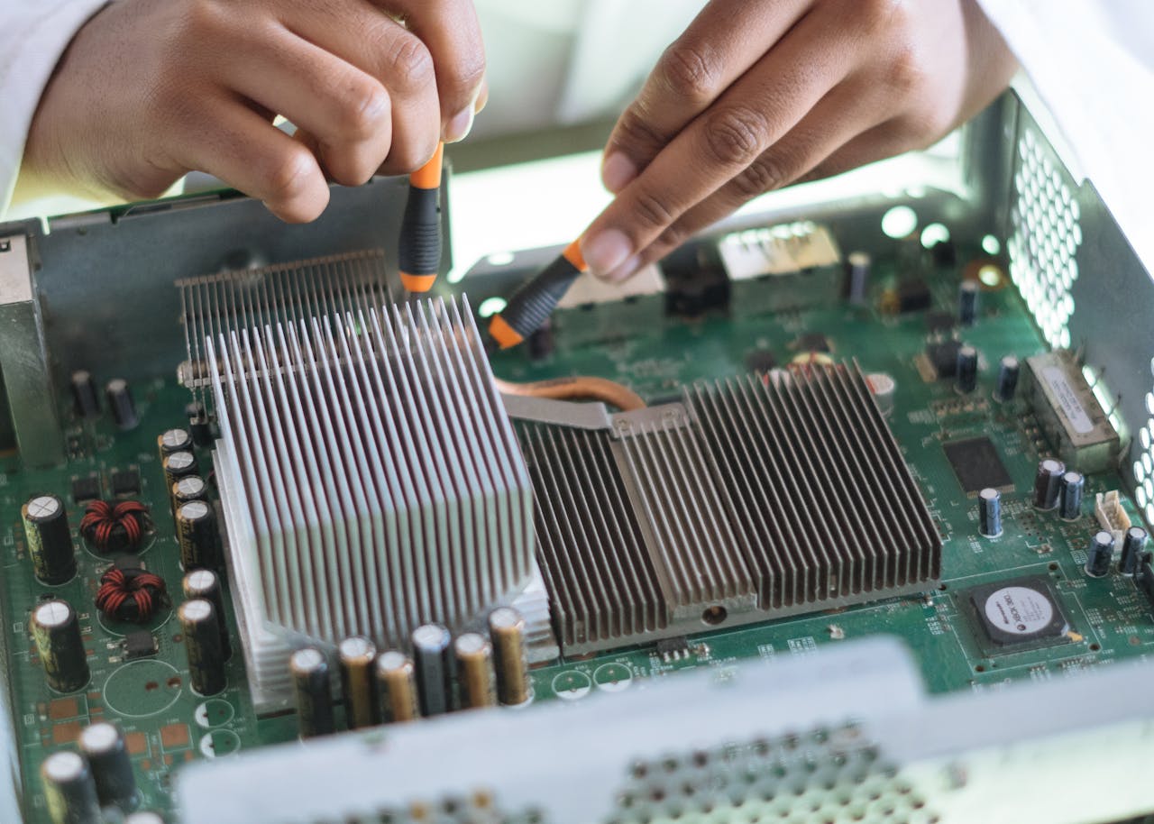 our-services-2 Close-up of a technician repairing a computer motherboard, focusing on microprocessor and heat sink.